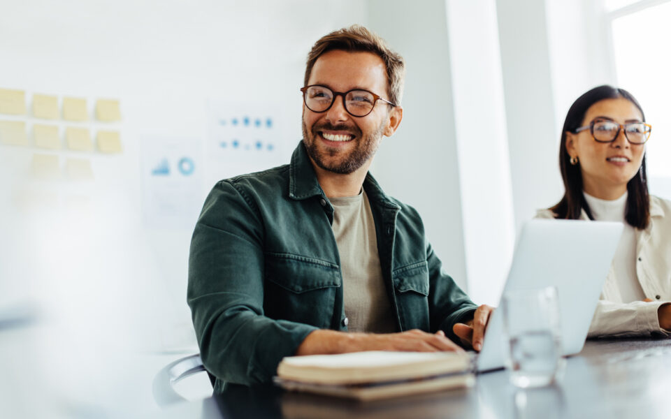 Happy business man listening to a discussion in an office